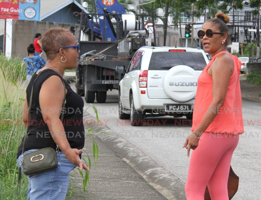 Kadaffi Romney, mother of Jehlano Romney, right, speaks to a relative at the Forensic Science Centre, 
St James. - Photo by Ayanna Kinsale