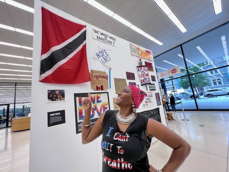 Nadine Otego Seiler looking proudly at the flag of Trinidad and Tobago at the opening of the Black Lives Matter Memorial Fence Collection Exhibit, Martin Luther King Jr Memorial Library, October 26, 2022. Photo courtesy Robin Fader Photography
