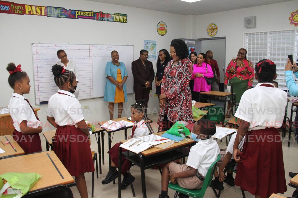 Education Minister Dr Nyan Gadsby-Dolly, centre, speaks with students in one of the classrooms of the newly built Fanny Village Government Primary School after its commissioning on Monday as staff members and ministry officials look on. - Marvin Hamilton