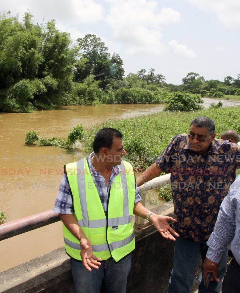 In this 2017 photo, then Sangre Grande Regional Corporation chairman Terry Rondon listens to Works and Transport Minister Rohan Sinanan as they toured flood-affected areas in north-east Trinidad. 