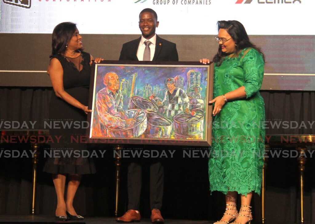 From left, Paula Gopee-Scoon, Minister of Trade and Industry; Grenadan Prime Minister Dickon Mitchell; and Tricia Coosal, president of the Trinidad and Tobago Manufacturers' Association (TTMA).  
Paula Gopee-Scoon and Tricia Coosal present Prime Mister Mitchell with a painting done by artist Kibwe Loreilhe during the (TTMA) President's Dinner and Awards at the Hyatt Regency Ballroom, Port of Spain. - Photo by Ayanna Kinsale