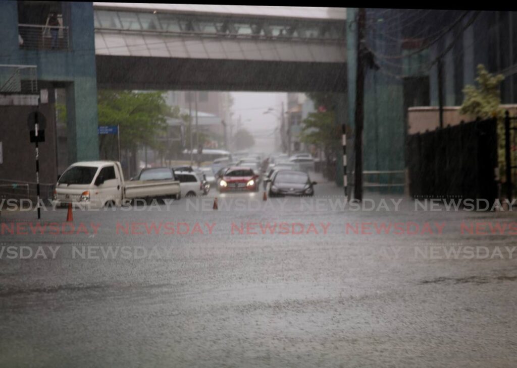 After some heavy rain around mid day on Thursday, Lower Richmond Street in Port of Spain looks more like the pond with traffic unable to move and   some cars caught up in the rising floodwater. - PHOTO BY SUREASH CHOLAI