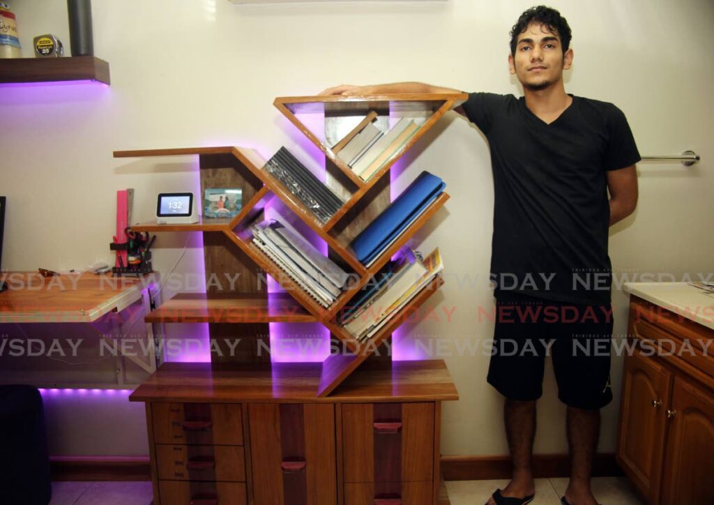 Cyrus Ageemoolar with one of his designs of a bookshelf illuminated with lights. - Lincoln Holder