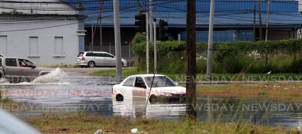 A vehicle had to be abandoned after it stalled on a flooded street near Abattoir Road in Port of Spain on Friday. - Photo by Angelo Marcelle