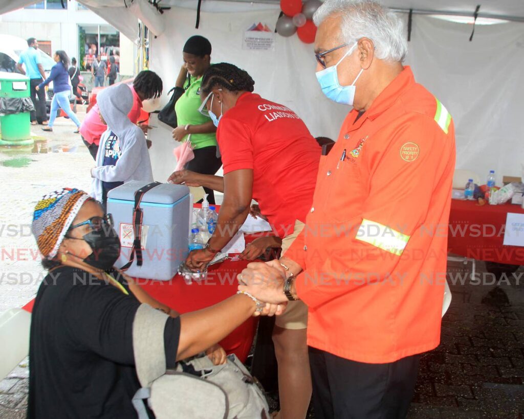 Health Minister, Terrence Deyalsingh, greets Newsday reporter Paula Lindo after she received her flu vaccine during the influenza vaccination drive hosted by the Ministry of Health and the NWRHA at the Brian Lara Promenade, Port of Spain, on Friday. - Photo by Roger Jacob