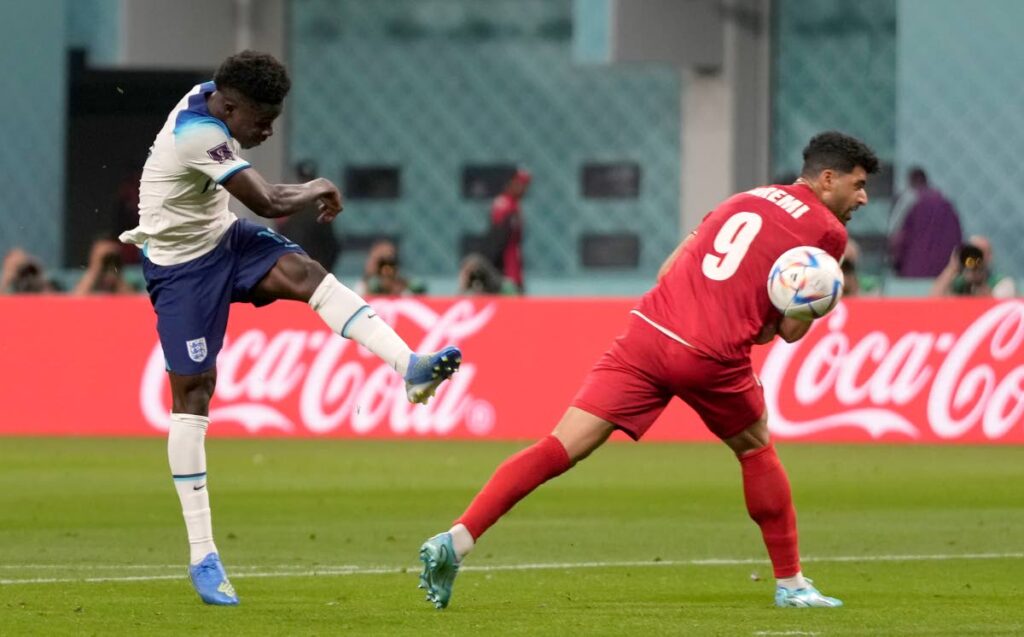 England's Bukayo Saka, left, scores against Iran in a World Cup group B match at the Khalifa International Stadium in Doha, Qatar, Monday. - AP