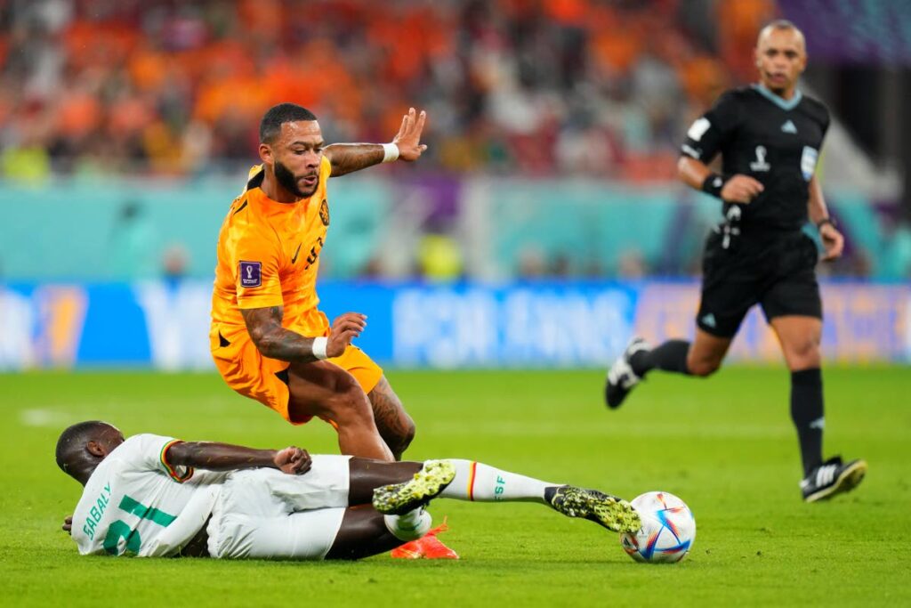 Senegal's Iliman Ndiaye, below, and Memphis Depay of the Netherlands battle for the ball during the World Cup, group A match at the Al Thumama Stadium in Doha, Qatar, on Monday. (AP PHOTO) - 