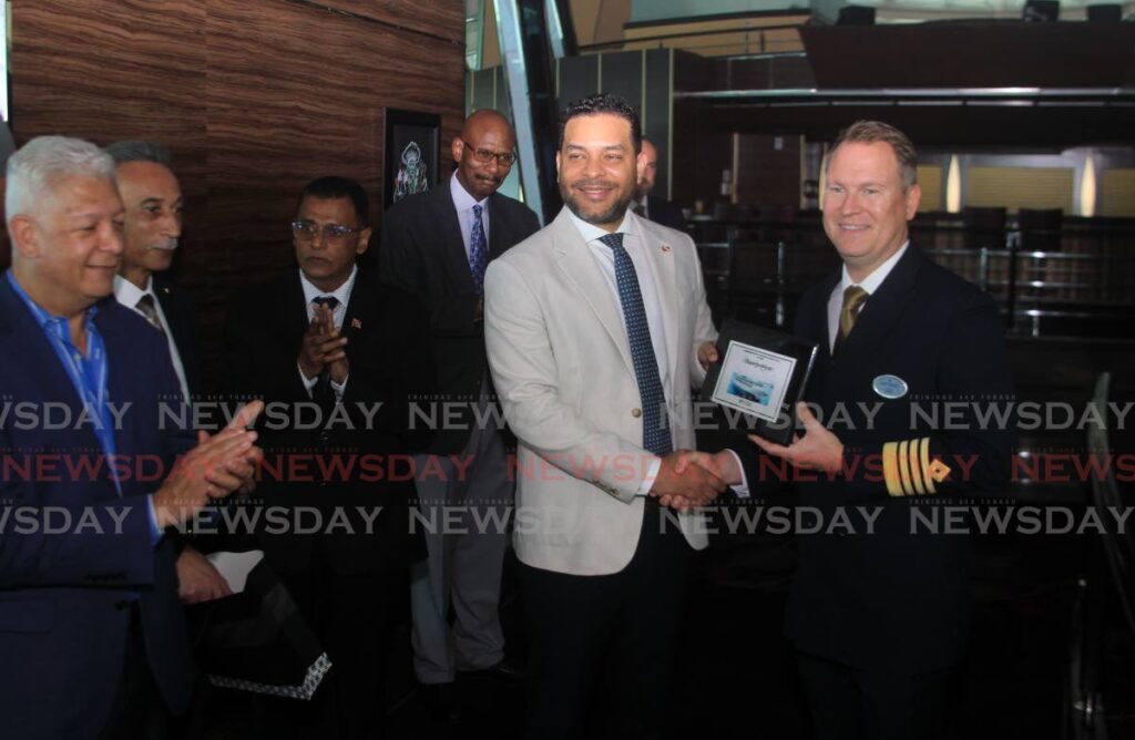 Captain Mathias Sebom of Royal Caribbean cruise line's Rhapsody of the Seas presents  Minister of Tourism Randall Mitchell with a token of appreciation as Port of Spain Mayor Joel Martinez, Minister of Works and Transport Rohan Sinanan, CEO of TT Sightseeing Tours Charles Carvalho and chairman of Tourism Trinidad Cliff Hamilton looked on.
 - Photo by Roger Jacob