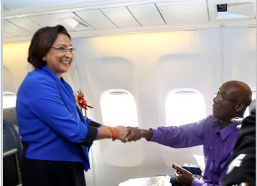 In this December 2012 photo prime minister Kamla Persad-Bissessar greets opposition leader Dr Keith Rowley onboard the CAL flight to Johannesburg for the memorial of former South African president Nelson Mandela. - 
