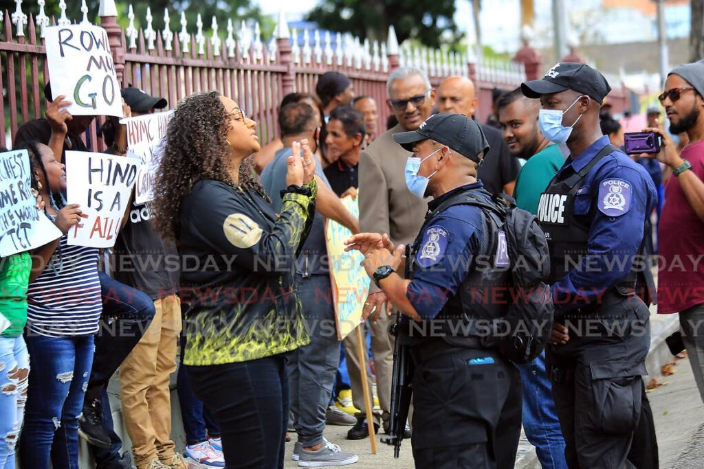UNC activist Marsha Walker faces off with policemen who asked her to lower her volume while debate on a motion on crime was happening in the House of Representatives. - SUREASH CHOLAI
