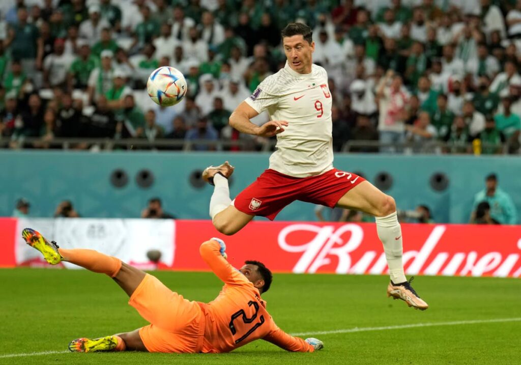Saudi Arabia's goalkeeper Mohammed Al-Owais, left, makes a save in front Poland's Robert Lewandowski, right, during the World Cup group C match, at the Education City Stadium in Al Rayyan , Qatar, on Saturday. (AP Photo) 