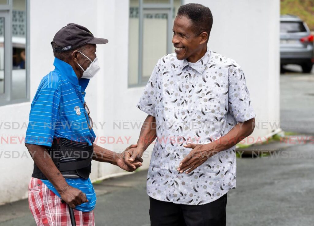 Carlton Fauston, left, meets Learie Paul, right, chairman of PNM Tobago Council, after voting at PNM internal election at Caroline Building, Scarborough, on Saturday - Photo by David Ried