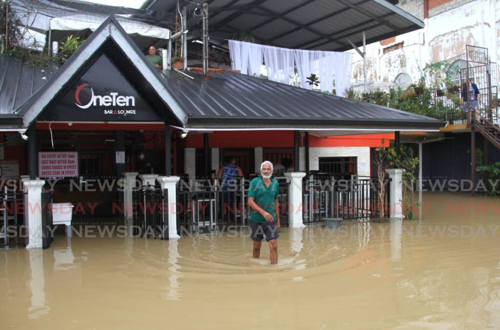 A Gasparillo resident walks through flood near a local bar on Saturday.  - AYANNA KINSALE