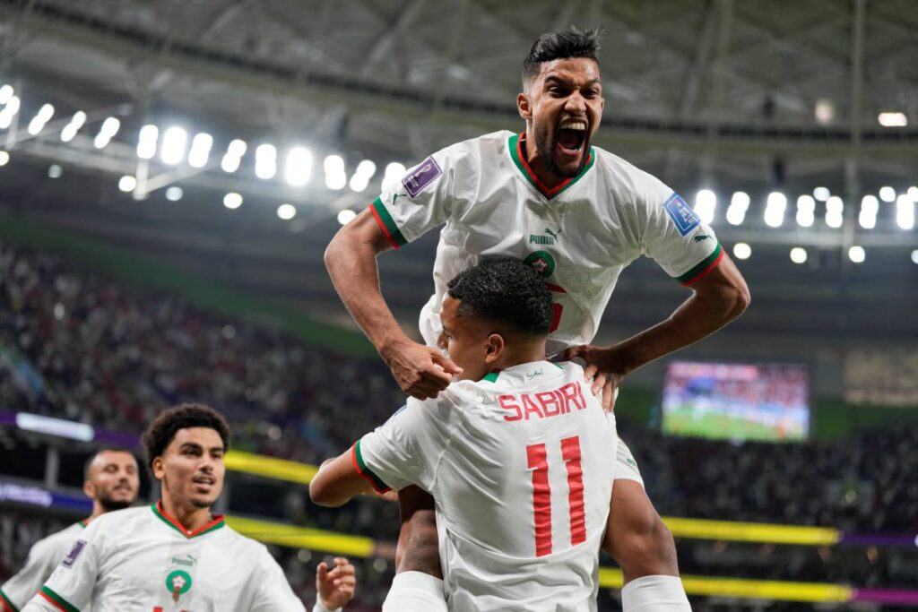 Morocco's Yahya Jabrane jumps on goalscorer Abdelhamid Sabiri during Sunday's 2-0 win over Belgium in World Cup group F action, at the Al Thumama Stadium in Doha, Qatar. - AP