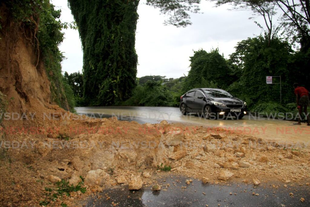 A driver makes his way past a landslide on Pointe-a-Pierre Road, San Fernando after constant rainfall on Sunday. - AYANNA KINSALE