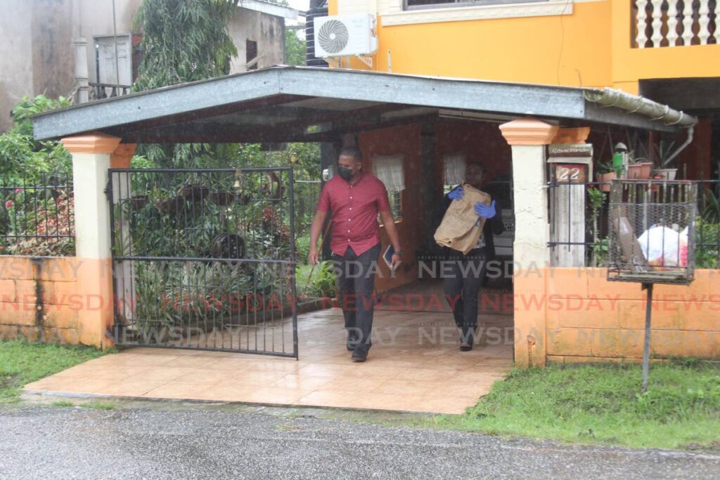 Homicide police leave the home of Patsy Ramcharan who was killed by a relative at her White Trace, St Mary’s Village, Moruga, home on Sunday.  - Lincoln Holder