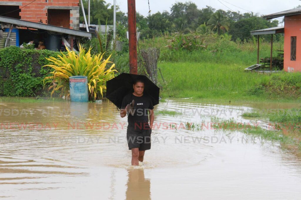 Gopie Trace, Penal, impassable owing to heavy rainfall. A resident took a chance on Monday to walk through the floodwater.  - Marvin Hamilton