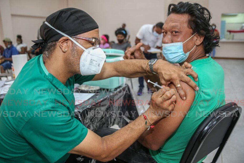 NWRHA employee Wendell Walters vaccinates a member of the public for covid19 at the Diego Martin South Community Centre, Diego Martin on October 9, 2021. - File photo/Jeff Mayers