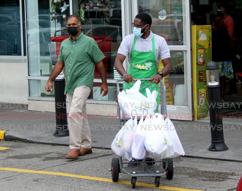 In this file photo a customer gets assistance to carry his groceries to his vehicle from a worker from Tru Valu, Long Circular Mall, St. James.  - 