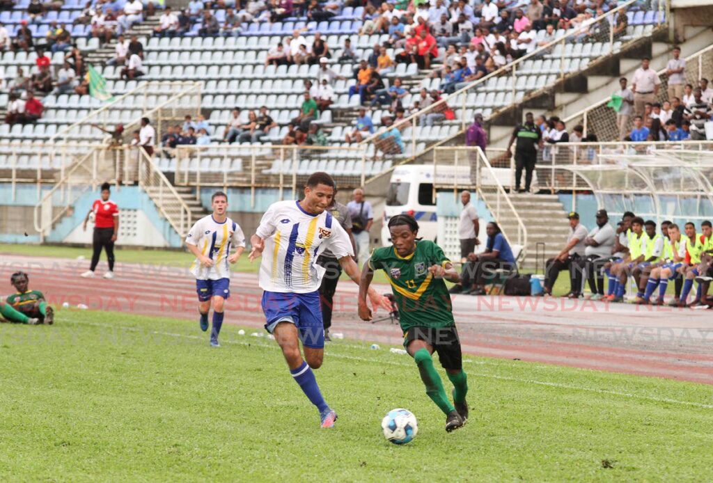 St Benedict’s College player Jeremiah Niles (R) runs with the ball during the SSFL Premiership division final, on October 26, at the Ato Boldon Stadium, Couva.  Photo by Marvin Hamilton