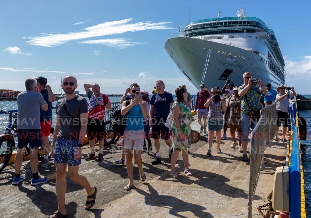 Tourists disembark the Rhapsody of the Seas cruise ship at the Scarborough port last month.  - David Reid