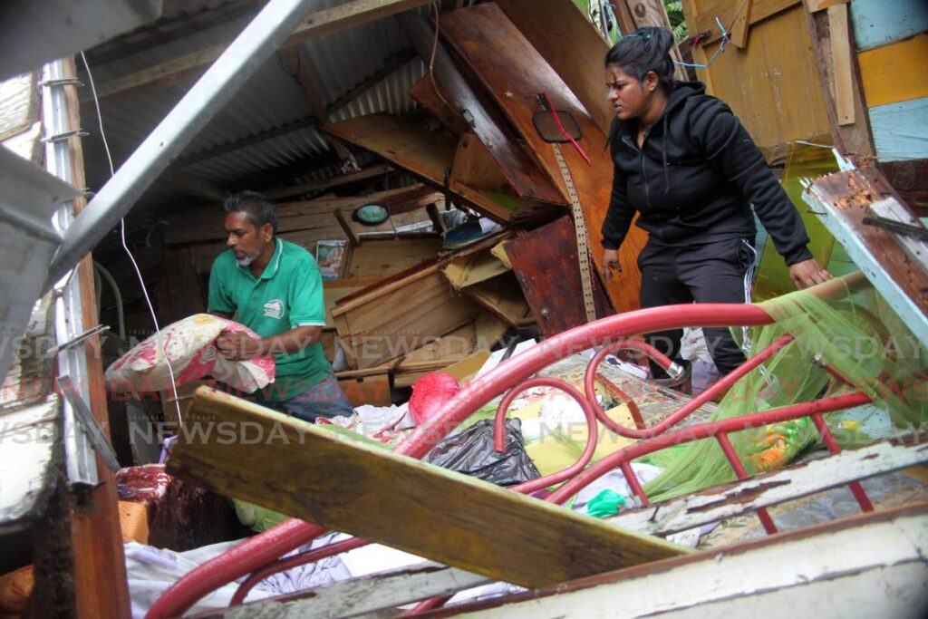 Relatives of the Mohess family help remove items from their Ramai Trace Debe home after it collapsed over the weekend due to land movement. Photo by Lincoln Holder