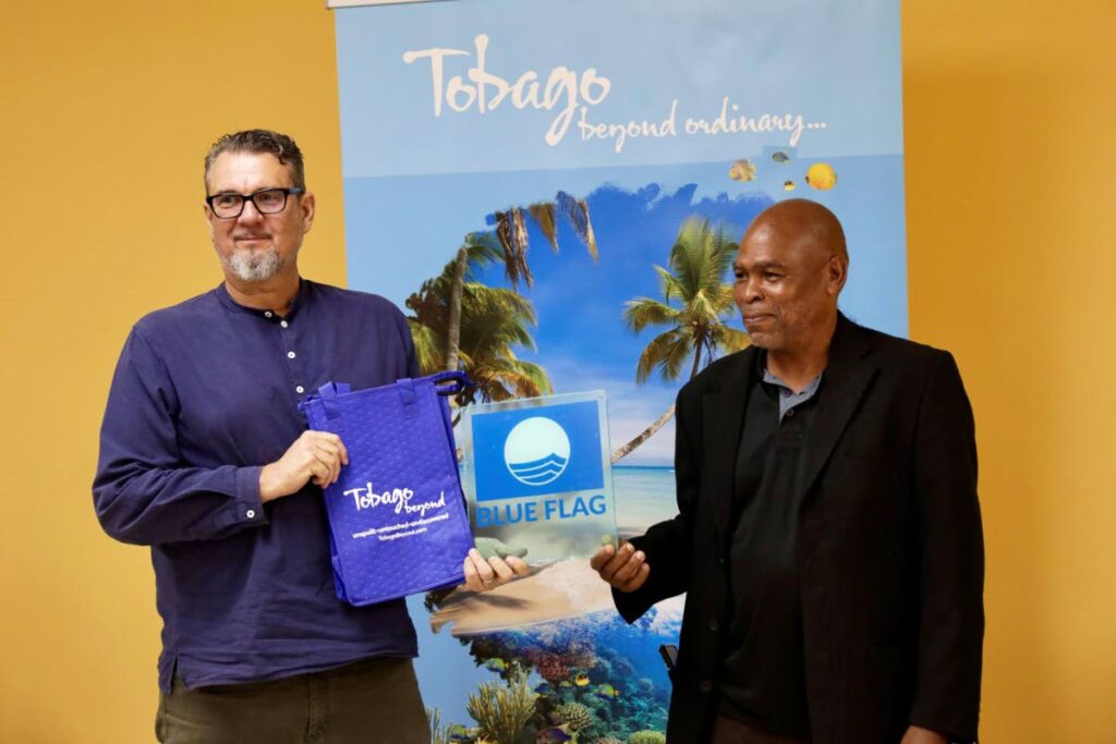 Aljoscha Wothke, chairman of Green T&T, left, presents the Blue Flag award plaque to Dexter Black owner/operator of tour boat Ms Ayana. Photo courtesy TTAL
