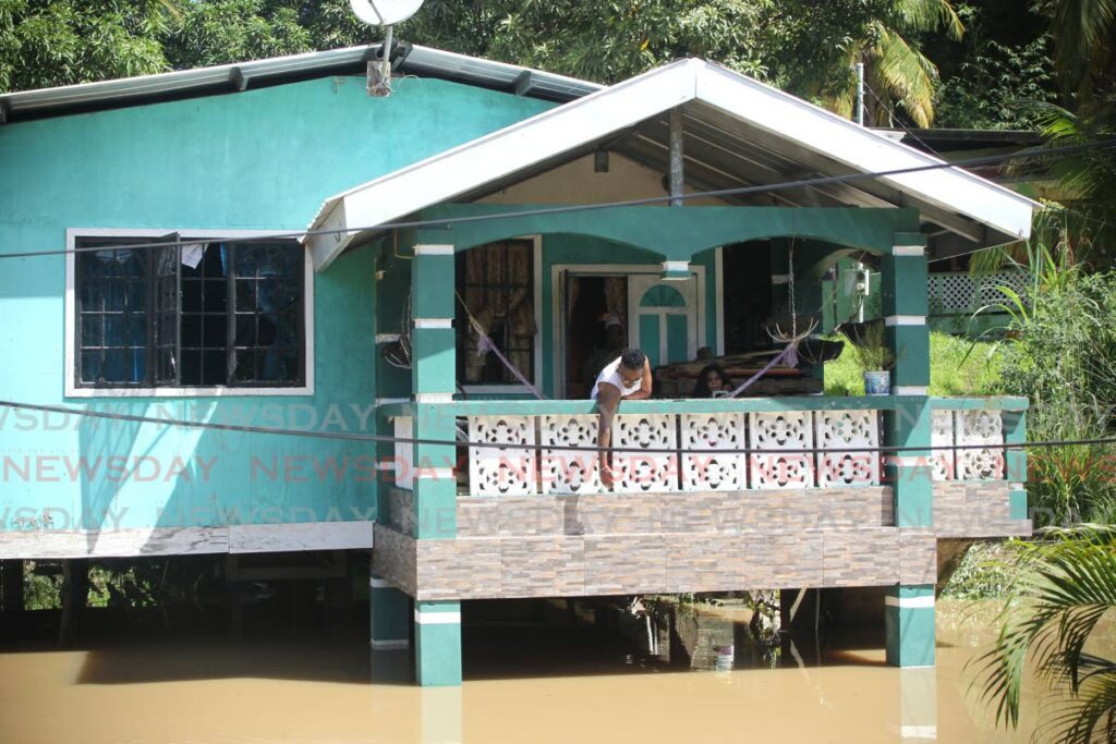 Inica Whiteman points to how high floodwater rose at her home in Mafeking village, Mayaro, on November 30, after the Ortoire river burst its banks. File photo/Lincoln HOlder
