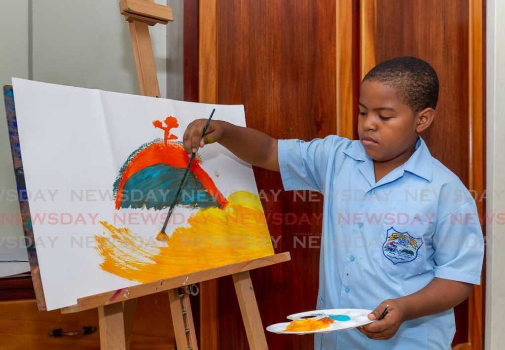 Quishang Jacob get joy out of painting as he applies brush strokes to a peice entitled Island.  Photo by David Reid