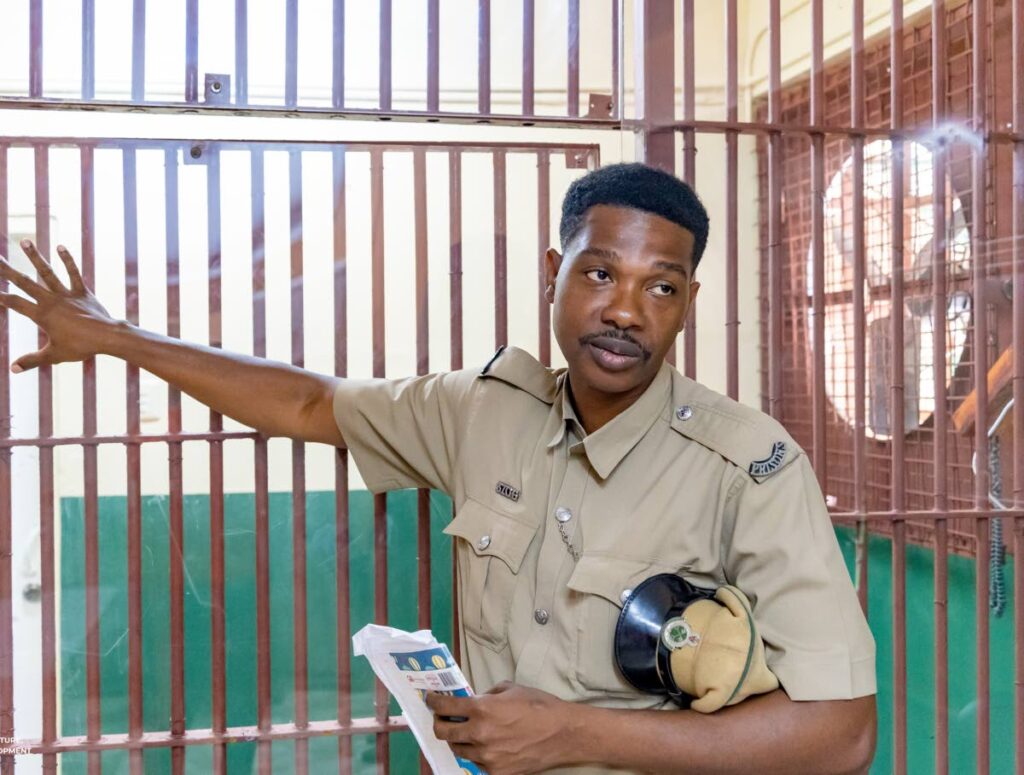 Programmes and Industry Officer Dwayne Cupid shows replaced Plexiglass and repainted bars at the Scarborough Prison.   Photo courtesy DIQUD