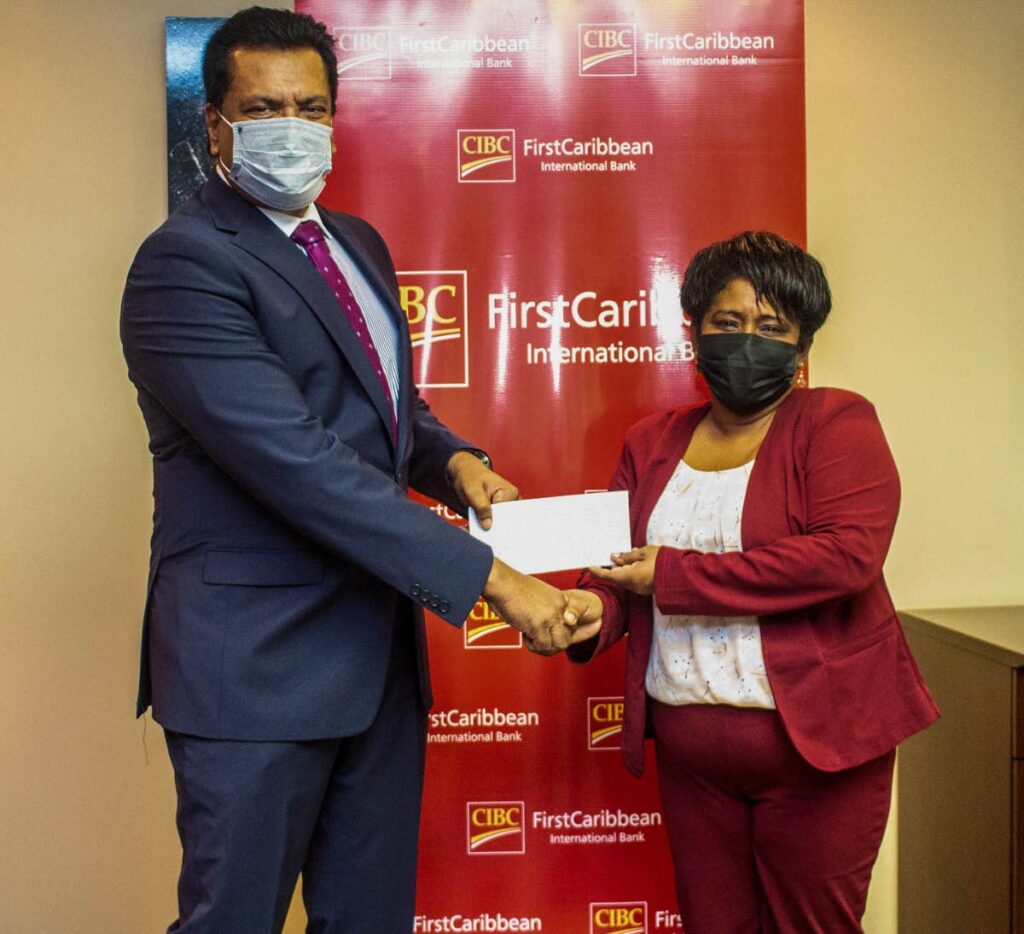 Principal of Nelson St Boys’ RC School, Frances Gervais-Heath, receives a donation from Anthony Seeraj, managing director of Trinidad Operating Company, CIBC FirstCaribbean. - 