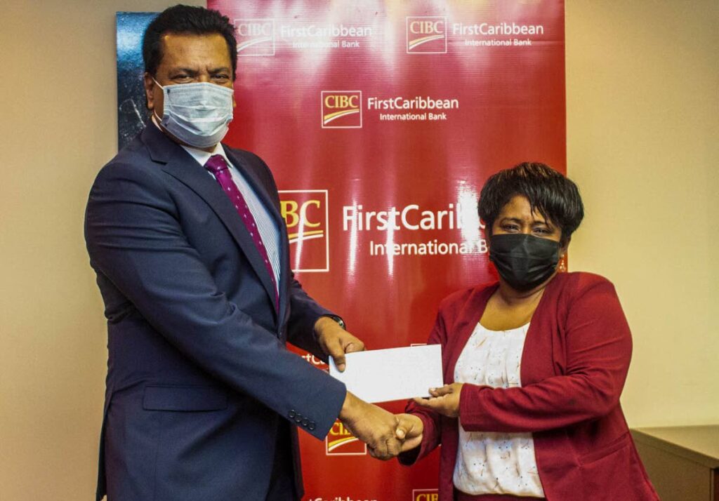 Principal of Nelson St Boys’ RC School, Frances Gervais-Heath, receives a donation from Anthony Seeraj, managing director of Trinidad Operating Company, CIBC FirstCaribbean. 