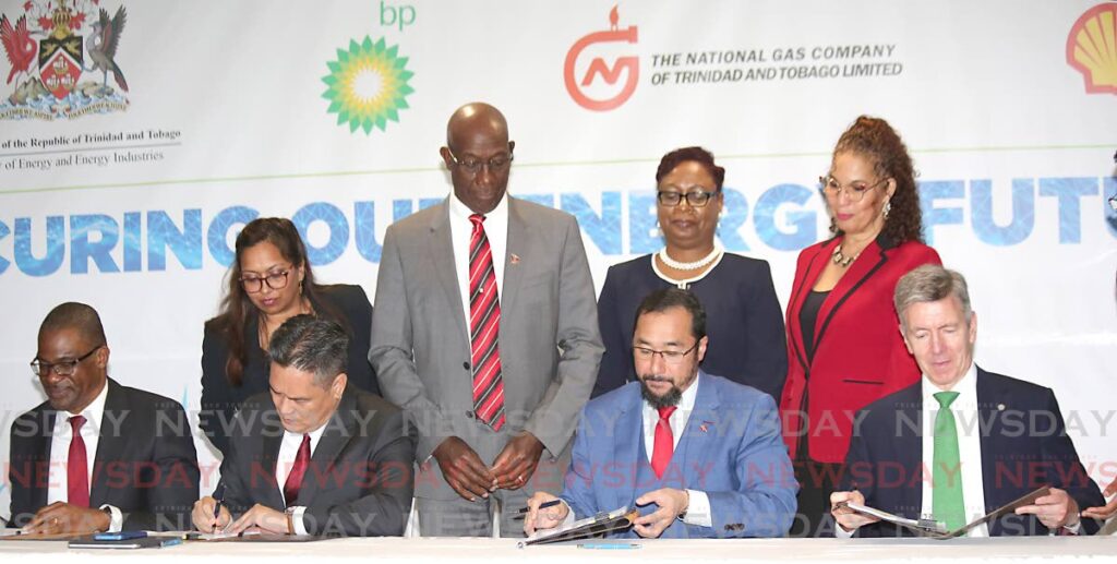 Prime Minister Dr Keith Rowley and government officials witness the signing of the heads of agreement of Atlantic LNG shareholders, from left, Shell TT country chairman Eugene Okpere, NGC president Mark Loquan, Energy Minister Stuart Young and bpTT president David Campbell at Hilton Trinidad, Port of Spain on Tuesday.  File photo/Sureash Cholai