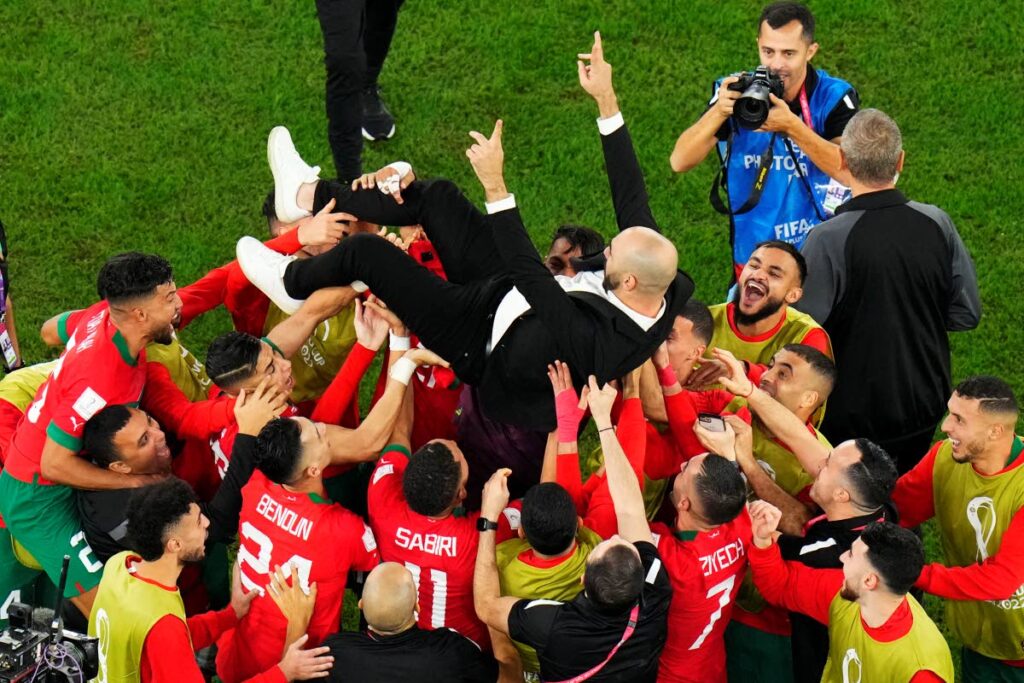 Morocco's head coach Walid Regragui is thrown in the air at the end of the World Cup round of 16 match against Spain, at the Education City Stadium in Al Rayyan, Qatar, on Tuesday. (AP Photo)  