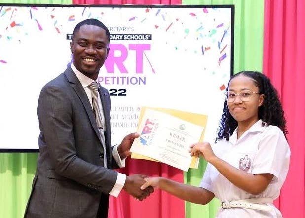 Chief Secretary Farley Augustine congratulates Bishop's High student Mateya Fraser, winner of the Chief Secretary Secondary Schools art competition, at Tuesday's prize-giving ceremony held at the Anne Mitchell-Gift Auditorium, Scarborough Library. Photo courtesy THA