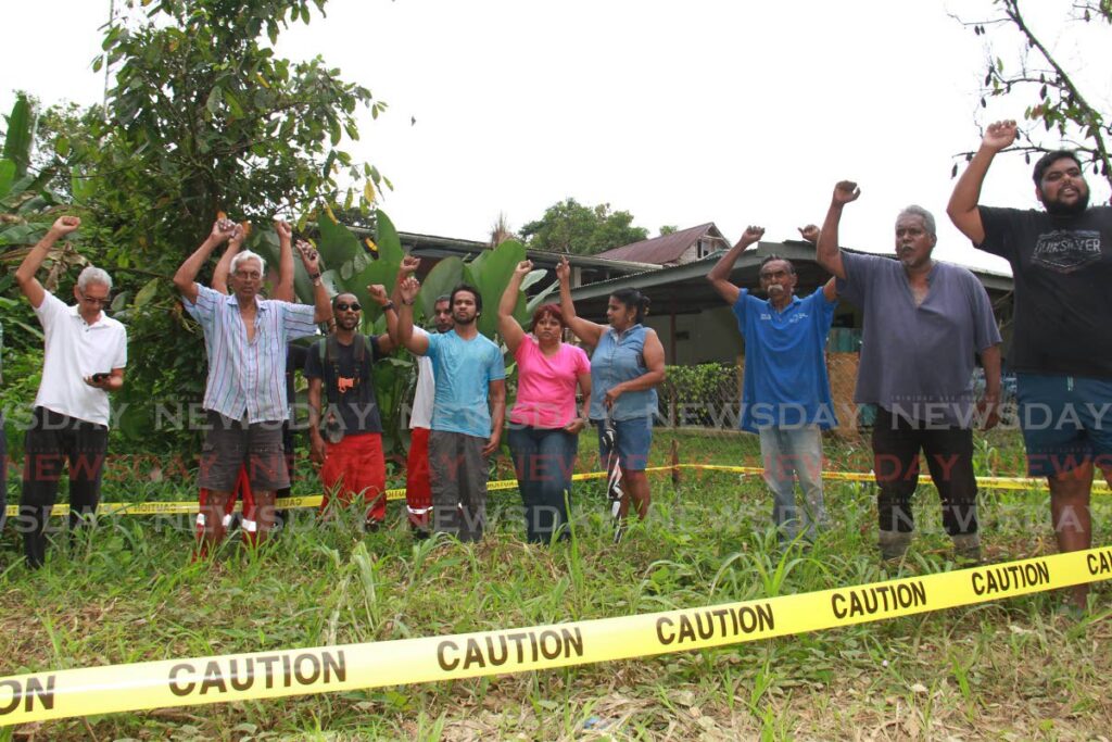 Residents of Siparia Old Road, Fyzabad stood on one of the sites marked with caution tape for the construction of a TT Electricity Commission transmission tower in the community. - Photo by Marvin Hamilton