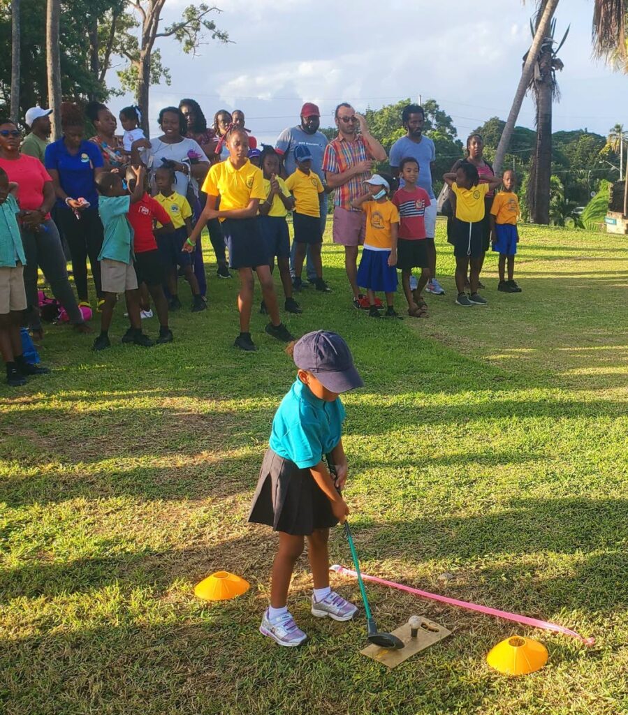 A young golfer gets set to drive the ball as a crowd looks at at the Mt Irvine Golf Academy's second annual tournament.  - 