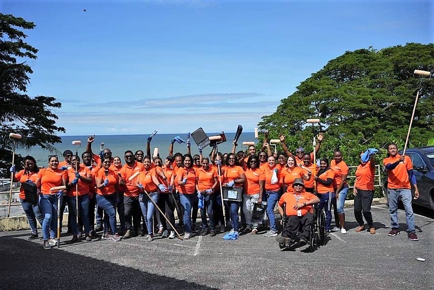 Simone Martin-Sulgan, general manager and vice president of Flow with  staff volunteers as they get ready to paint  the perimeter walls and classrooms at the National Centre for Persons with Disabilities. - 