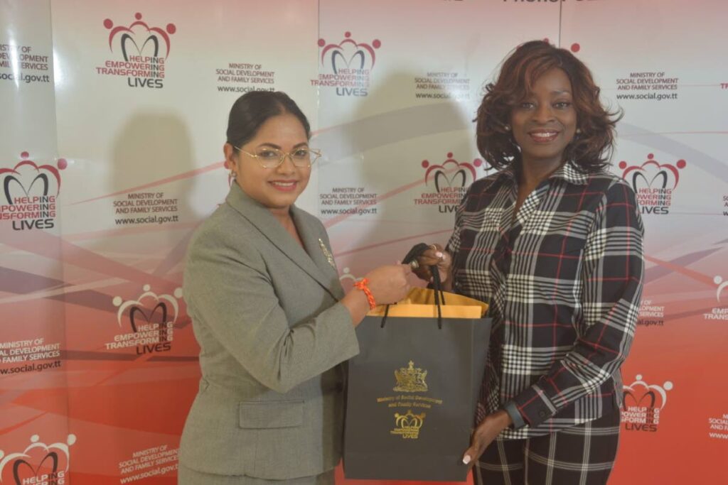 Minister of Social Development and Family Services Donna Cox, right, presents Vandana Mohit with about 200 food cards to be distributed to constituents in need over the Christmas season.  - 