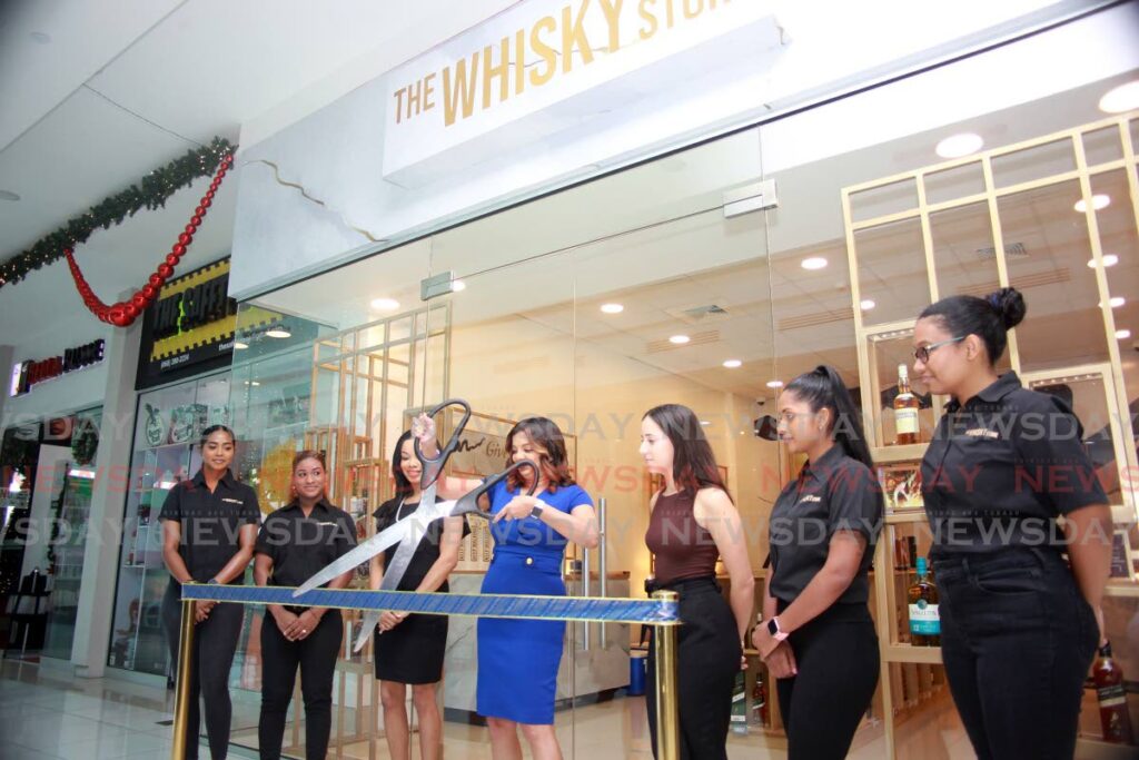 Daylene Raghoobar, marketing manager  AS Bryden, cuts the ribbon to open their Whisky store at C3 Mall, San Fernando. Raghoobar was joined by Zindzi-Renee Williams, brand mamager premium beverages, Raquel DuCoudray, brand manager Johnnie Walker reserve and staff members. Photo by Lincoln Holder