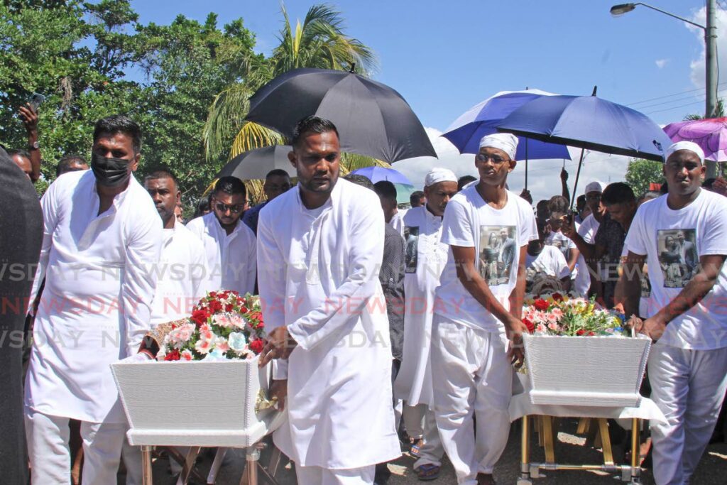 Pallbearers carry the caskets of Anita Jagdeo, 27, and her fiance Amar Randy Ramdass, 29, at the Waterloo Cremation Site on Saturday.  - Marvin Hamilton