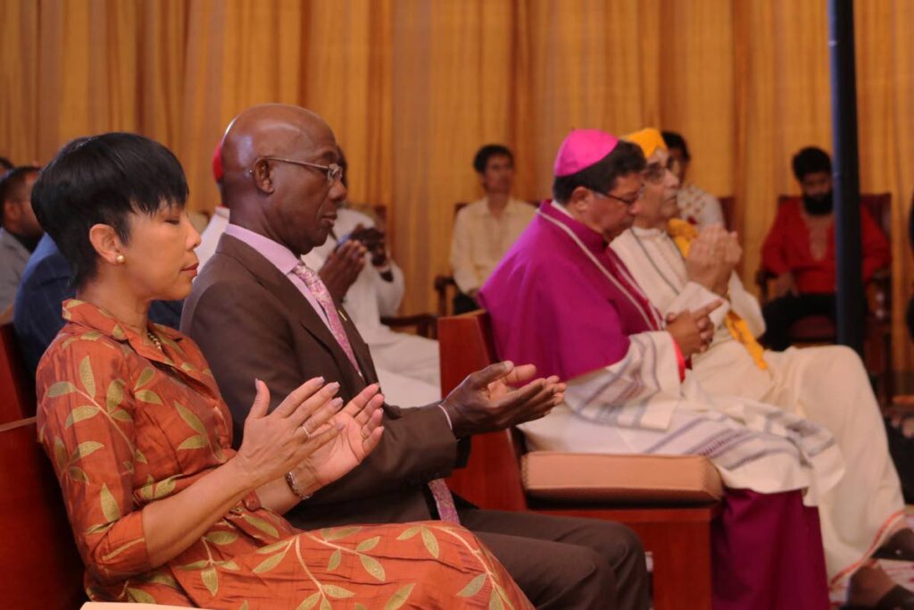 Prime Minister Dr Keith Rowley and his wife Sharon, left, are deep in prayer during the national service of reflection and thanksgiving on December 18 at the Diplomatic Centre, St Ann's. Photo courtesy Office of the Prime Minister