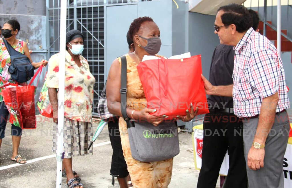 Coosal's Group of Companies executive chairman Sieunarine Coosal, left, gives a hamper to Yvette Babb-Lewis during the Salvation Army annual Christmas food hamper distribution at the Salvation Army Headquarters, Henry Street, Port of Spain, last Tuesday. Photo by Ayanna Kinsale
