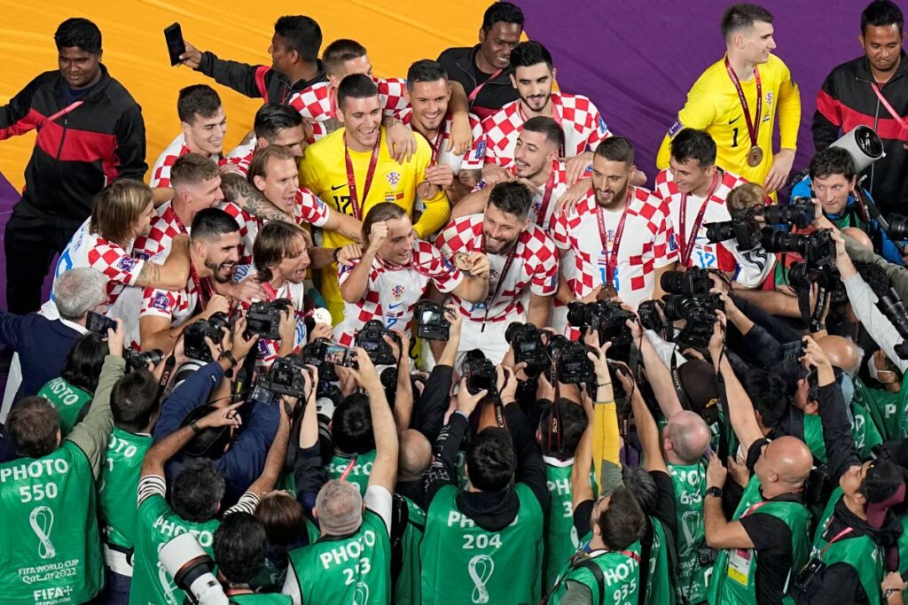 Photographers take pictures of the cheering Croatian players on the pitch after the World Cup third-place playoff match between Croatia and Morocco at Khalifa International Stadium in Doha, Qatar, on Saturday. (AP PHOTO) - 