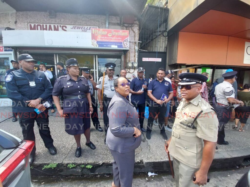 Ag Snr Supt Richard Smith, 2nd from right, and Snr Supt Lucia Winchester, centre, with police officers before a foot patrol on High Street, San Fernando on Monday. Photo by Lincoln Holder