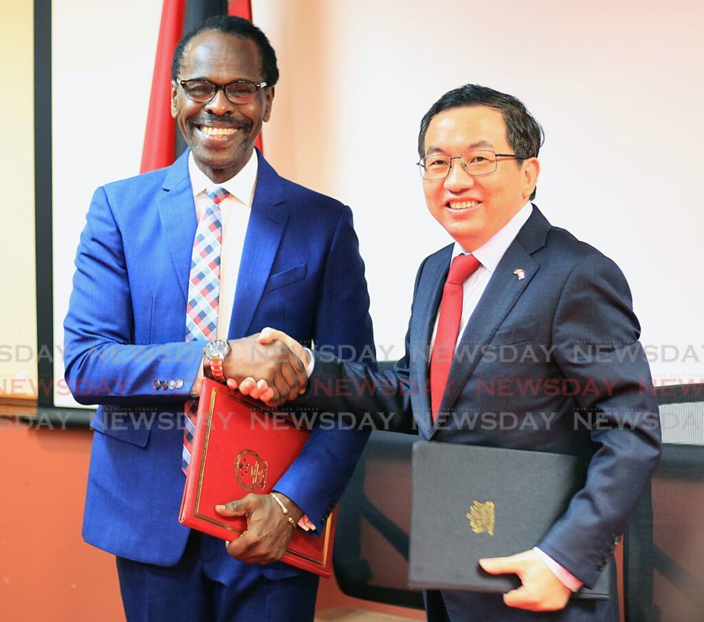 SIGNED: National Security Minister Fitzgerald Hinds, left, and China's ambassador Fang Qiu after the signing of an MoU on Monday at Tower C, International Waterfront Centre, Port of Spain. Photo by Roger Jacob