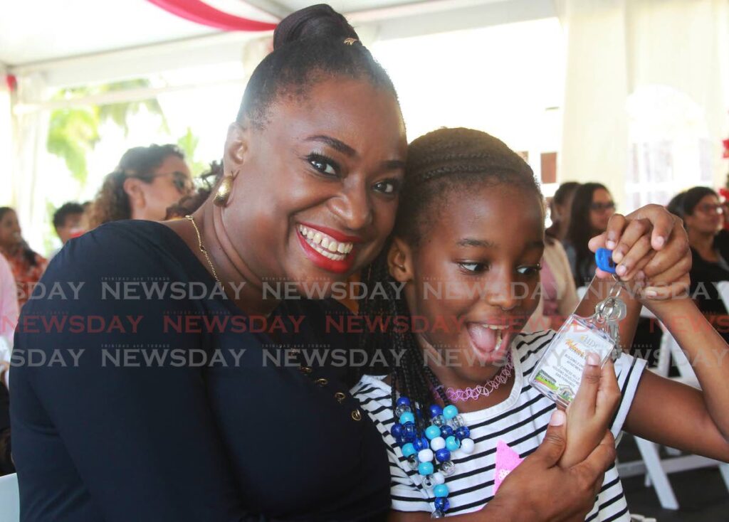 MUMMY, OUR KEYS: Kailyn McKnight cannot conceal her glee as she looks at the keys to her new home which she and her mother Allison Rian McKnight collected at an HDC key-distribution ceremony at The Village Plaza, Edinburgh 500 on Monday. Photo by Marvin Hamilton