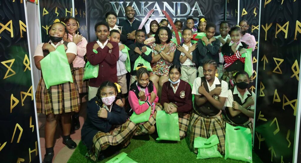 Students of La Pastora Government Primary School strike a pose with Minister of Education Dr Nyan Gadsby-Dolly and Langston Roach Industries CEO Sean Roach at MovieTowne, Port of Spain. 
