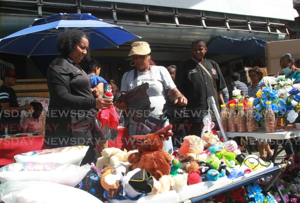 A customer took advantage of sale in San Fernando as vendors came out fully stocked on Wednesday in anticipation of the demads by shoppers for the Christmas season on High Street. Photo by Marvin Hamilton