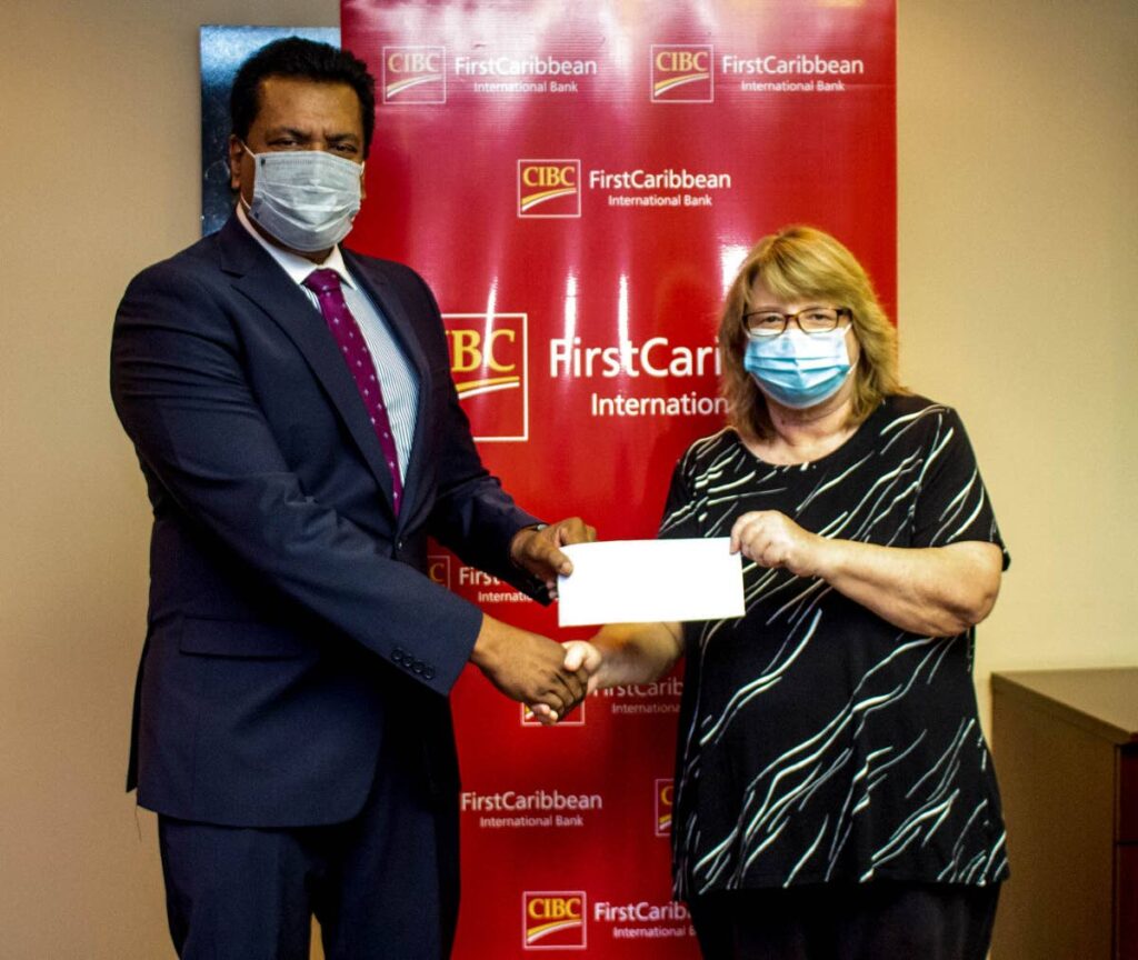 CIBC First Caribbean managing director Anthony Seeraj presents the ComTrust donation to Michelle Acqui from the Living Water Community.